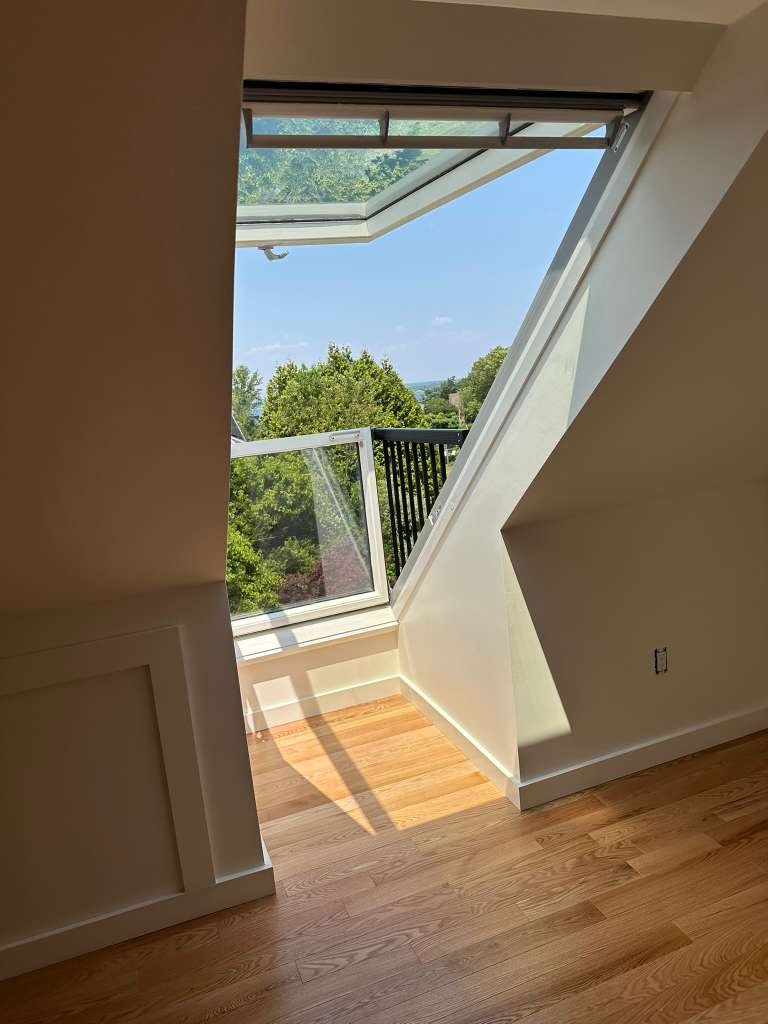 Interior dormer with hardwood floors and bright window